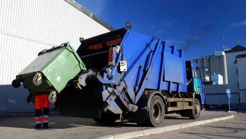 Construction site with builders clearing waste in Stratford